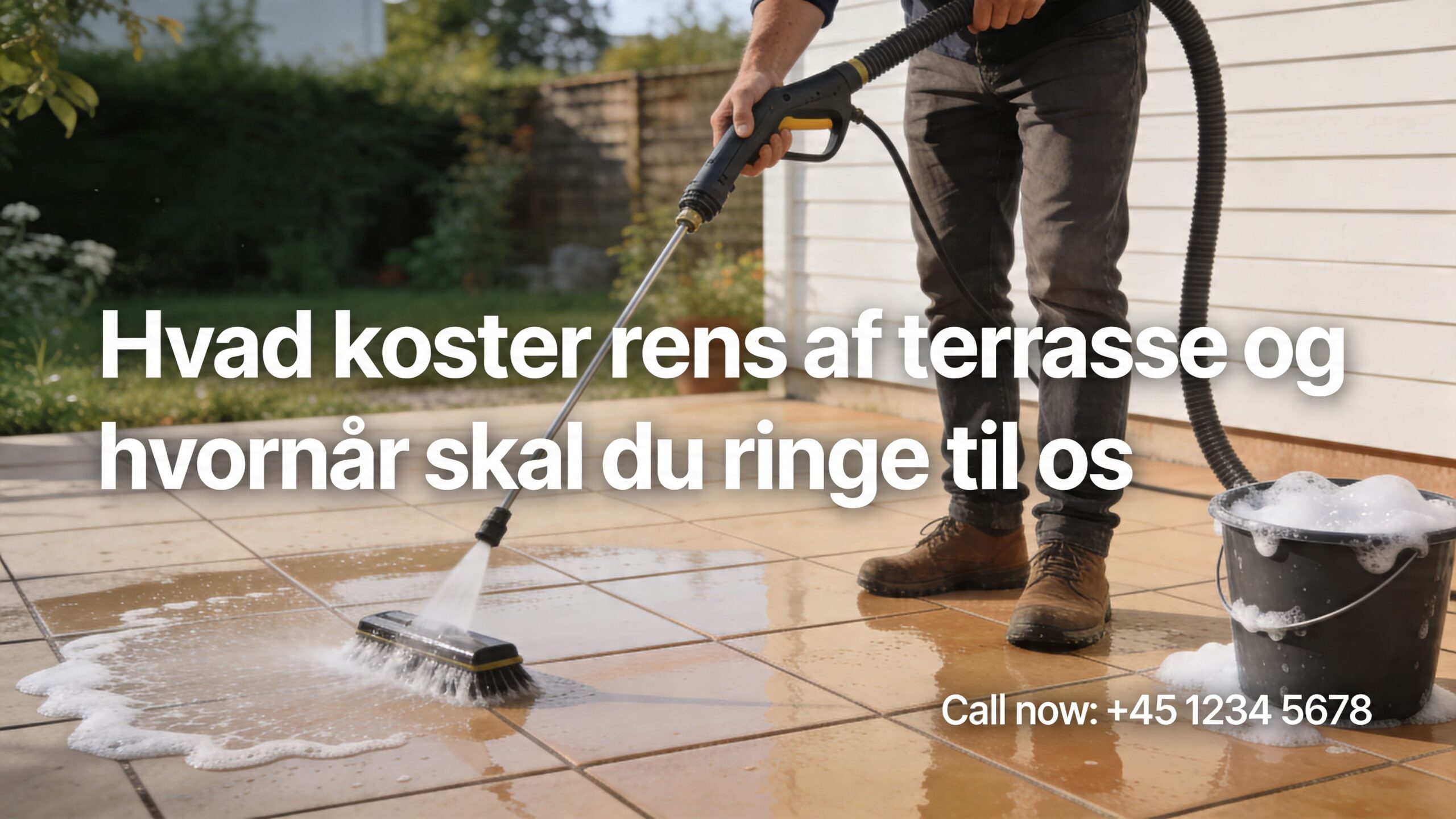 En person renser en flisebelagt terrasse med en højtryksrenser for at fjerne snavs og alger effektivt.